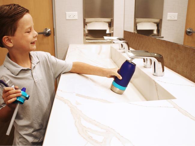 Child filling up water bottle